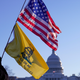 A man walks with a Gadsden and American flags outside the U.S. Capitol, a day after supporters of U.S. President Donald Trump occupied the U.S. Capitol Building in Washington, U.S. January 7, 2021. REUTERS/Erin Scott